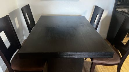 Brown real wood dining table and four chairs