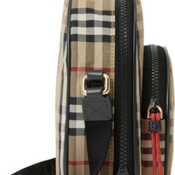 crossbody bag styled with a circular front pocket and finished with color-pop zip pulls.