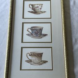 Framed triptych of signed watercolor prints of teacups by Carolyn Shores Wright. 25.5”x 14.5” Including Frame