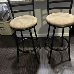 Two matching black metal swivel barstools