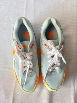 Kids Nike pale blue sneakers with orange and yellow accents