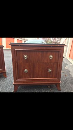 Two large wooden nightstands with black tops