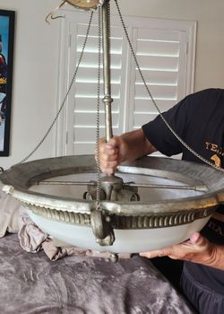 Silver tone chandelier with white and gray globe on bottom looks like marble