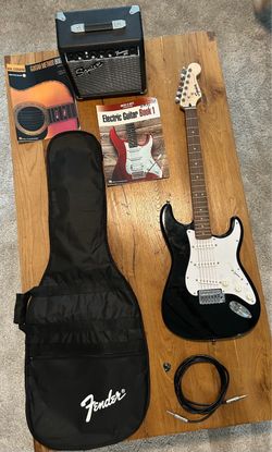 Electric guitar with amplifier case and books