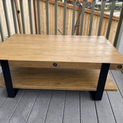 Coffee table With lower shelf made of reclaimed wood and a sleek looking modern metal frame.
