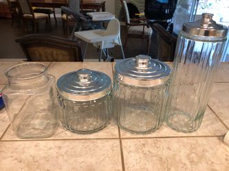 Three glass canisters and one glass vase