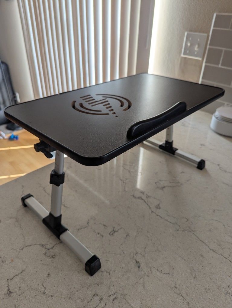 Laptop lap desk with adjustable angle, foldable leg, and working fan.