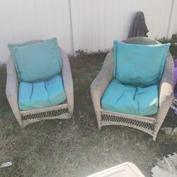 Two wicker chairs with cushions