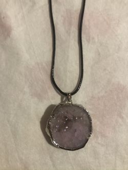 Druzy pink stone pendant with black cord.