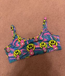 New Bright crop tank top with repeating neon smiley-face print. Soft, stretchy fabric for a snug fit. Bold swirl background with playful, colorful gra