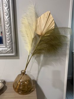 Vase with feathers and leaf
