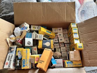 collection of vintage projector lamps and their original packaging. These are replacement lamps used in older movie and still projectors