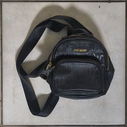 black Steve Madden mini backpack purse with an embossed logo and gold-tone hardware. 