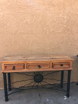 rustic southwest console table featuring a solid pine wood top, three utility drawers, and an ornate hand-forged wrought iron base