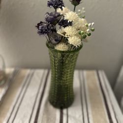 Green Glass Vase With Artificial Flowers And Rocks At The Bottom 