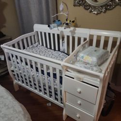 Crib with Changing table and drawers.