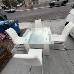 Modern glass dining table with 4 white chairs
