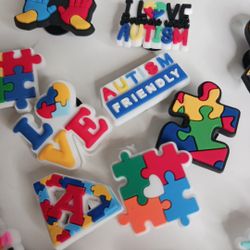 The product is a Crocs shoe charm featuring a variety of colorful designs that promote love and support for children with autism. Made of water-resist
