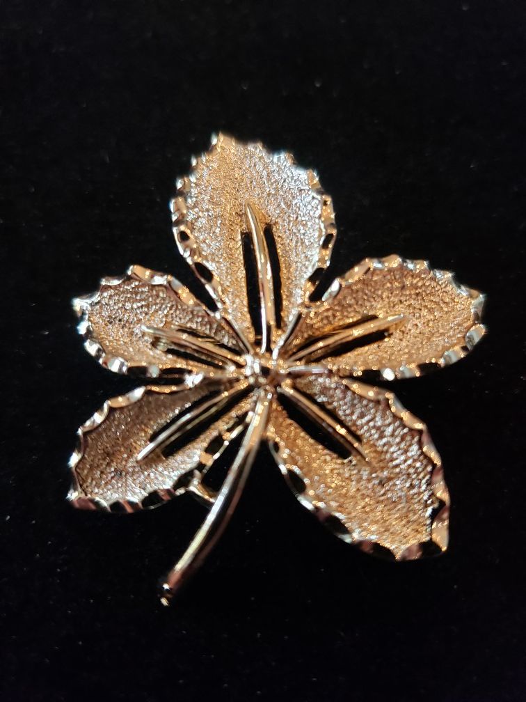 Vintage Sarah Coventry gold tone flower brooch. Measures 1.75 in long. 1.5 in wide.