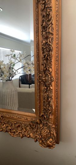 Late 20th Century Ornate Baroque-style gold-finished decorative wall mirror.