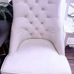White leather upholstered chair with tufted detailing,