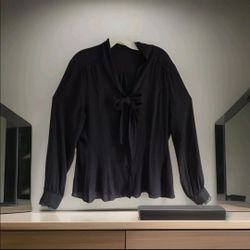 Elegant vintage black blouse with a soft, lightweight feel. Features a classic button-down front, long sleeves, and a stylish necktie bow. Lace trim a
