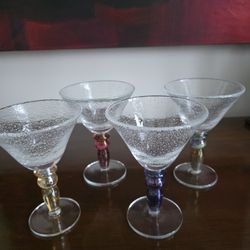 Set of four bubble glass stemmed glasses with colorful segmented stems.