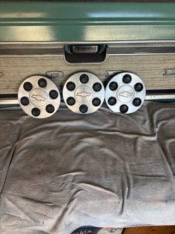 Three Chevy hubcaps.