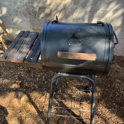 Black barrel grill smoker with side shelf and wheels
