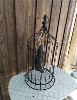 Swinging faux bird in bird cage decor