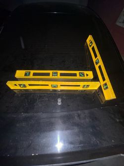 These look like three yellow spirit levels (likely 24-inch or similar size)