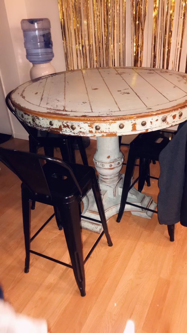 Turquoise Table With Four Black Stools