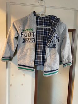 Versatile grey zip-up hooded jacket with a navy and white plaid lining. This Pepco brand garment has a cotton-blend jersey exterior and a smooth synth