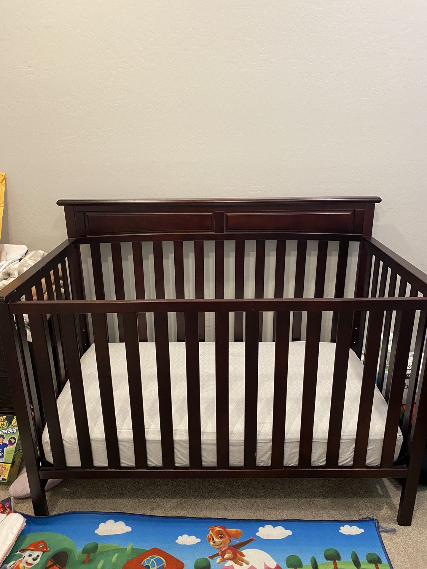 Dark brown Baby Crib with mattress.