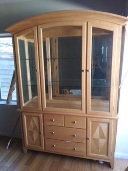 Glass and wooden shelf cabinet with drawers.