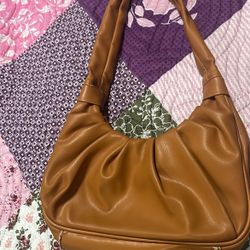 orangish copper shoulder bag, black and white pokodat inside