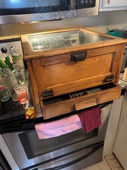 Wooden and glass display case with cash drawer.