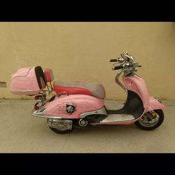 A pink motor scooter