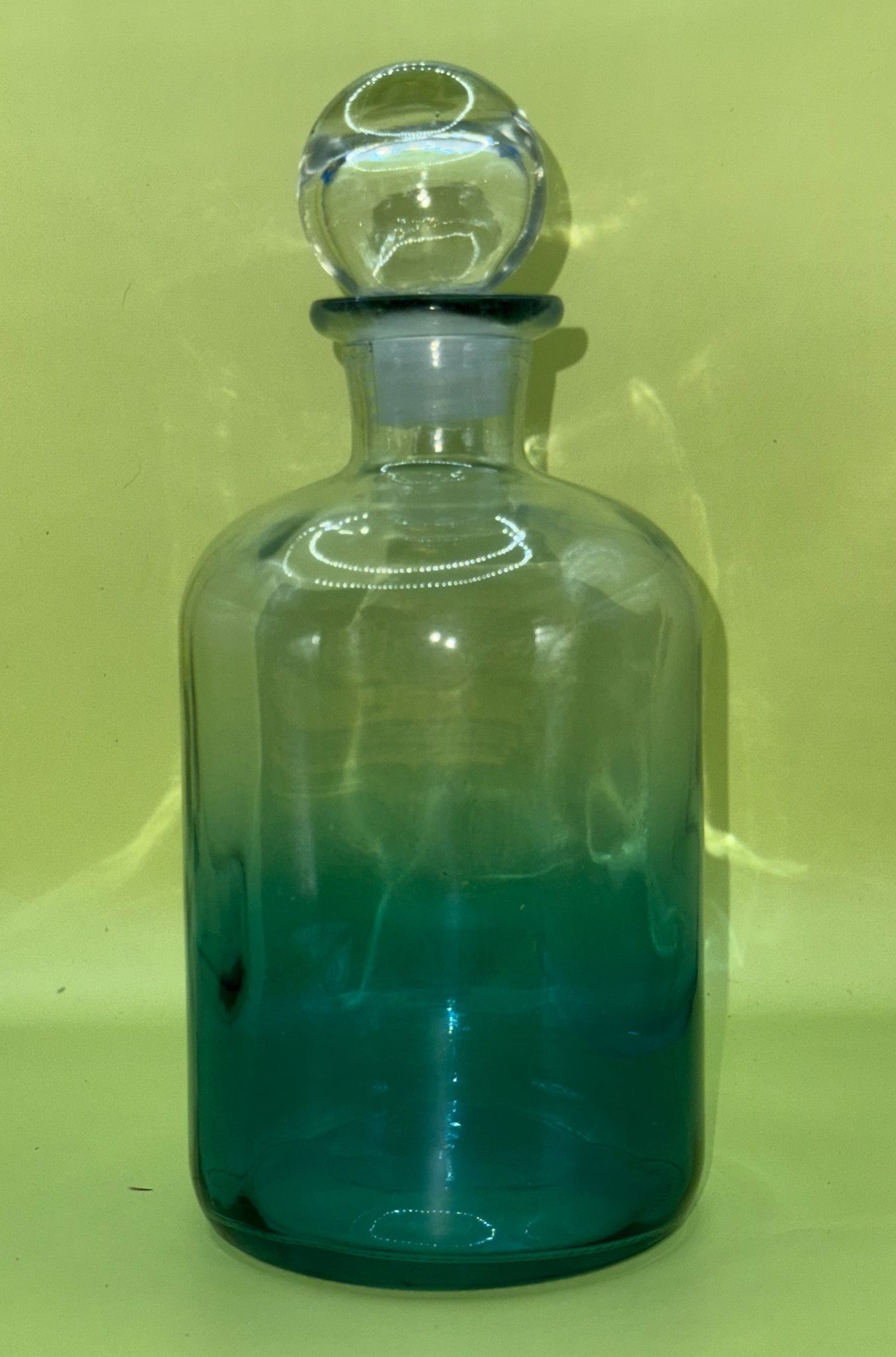 Blue ombré glass bottle decanter with a glass ball stopper.