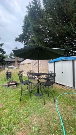 Metal patio set! Includes a table, tall swivel chairs, umbrellas, and a base. The umbrella is high quality but has some sun-fading; everything is in v