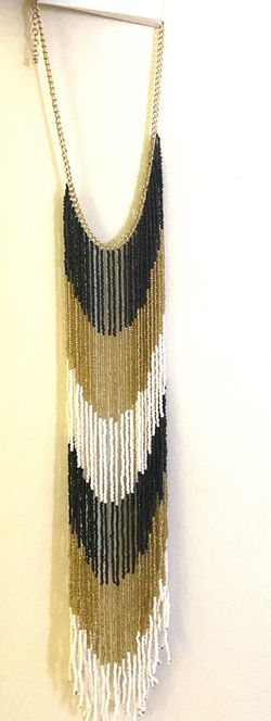 Beautiful Gold, black and white necklace. Makes a simple dress look nice. This necklace is one of a kind. You won’t be disappointed in buying it.