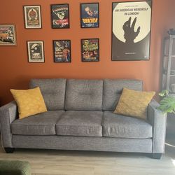 Grey Couch With Several Pillow Covers
