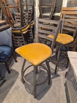 black finish ladder back swivel BAR STOOL with 2 1/2" light brown vinyl padded seat.