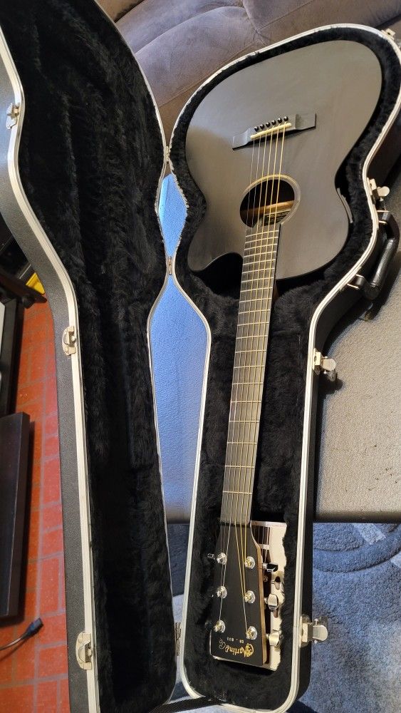 MARTIN 00CXAE IS A THIN-BODY ALL-BLACK, ACOUSTIC-ELECTRIC GUITAR WITH A CUTAWAY MADE IN USA.