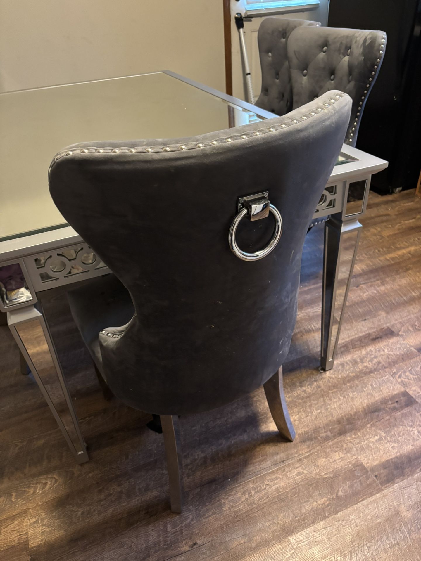 Mirror top table with 4 gray velvet like chairs.