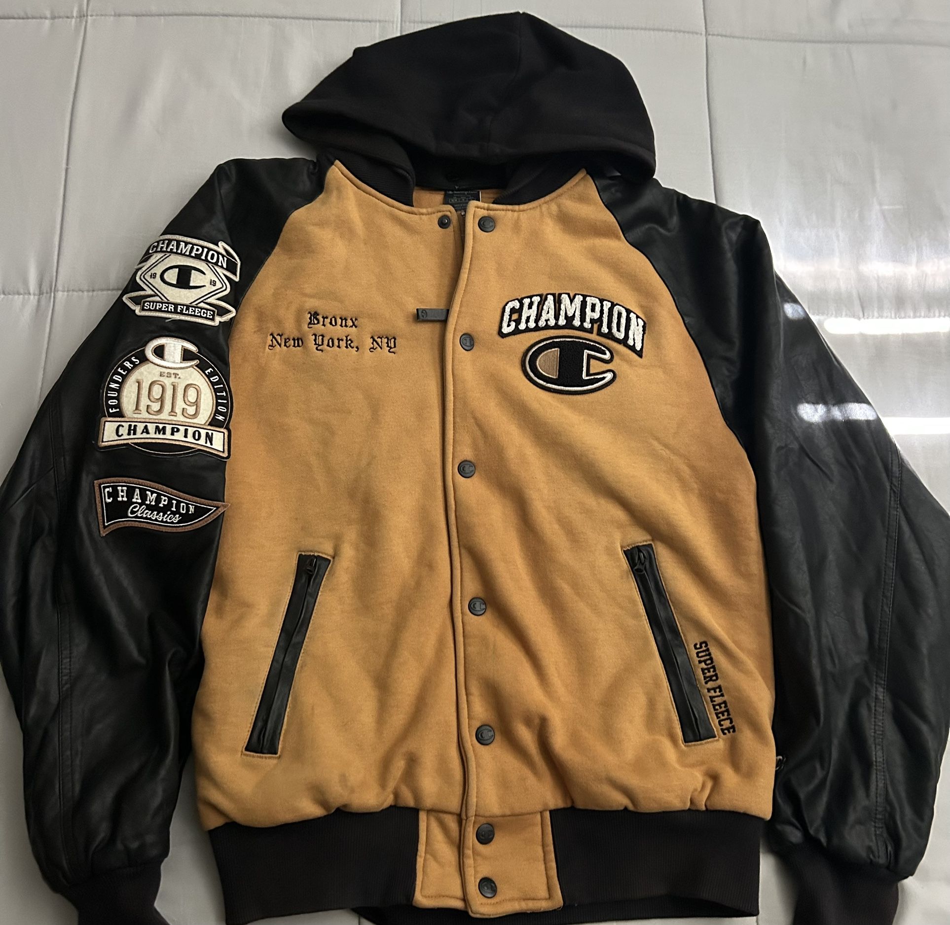 The jacket shown is a Champion Super Fleece varsity jacket with black leather sleeves.