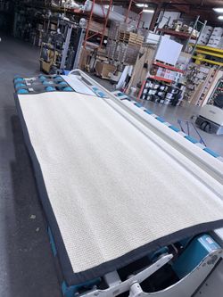 White wool rug w/black binding