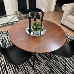 Round wooden table with three chairs
