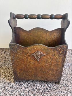 Magazine rack, antique with sculpture on it Magazine rack, antique with sculpture on it