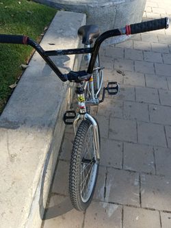The image appears to show a vintage or mid-school chrome BMX bicycle, Mongoose-branded saddl